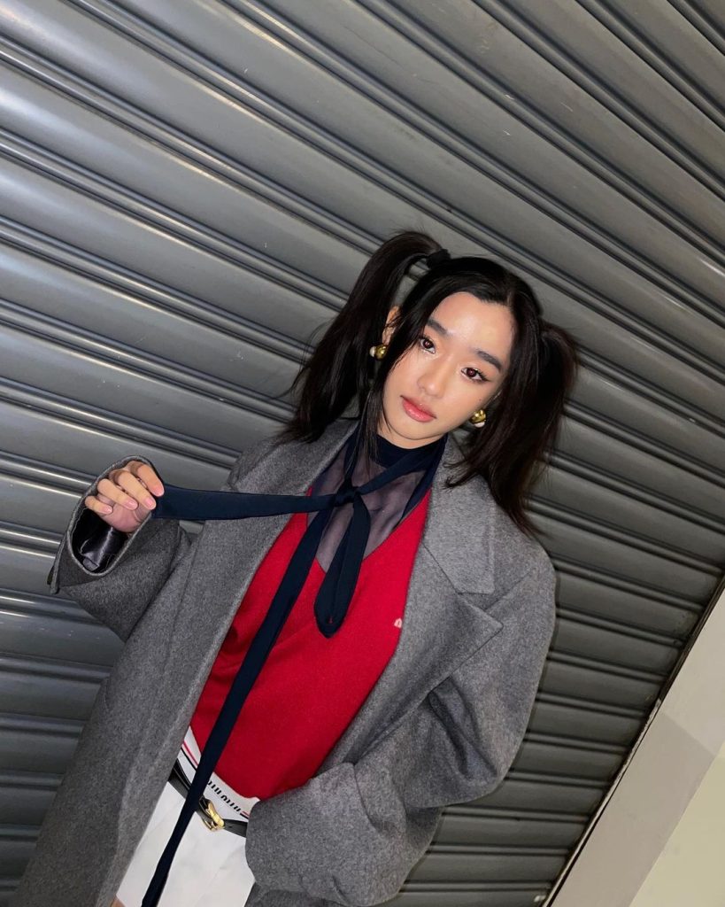 One of Tu Tontawan's styles involve her wearing a loose tie and grey blazer with pigtails.